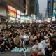Hundreds of pro-democracy protesters watch a live broadcast of a meeting between student leaders and government officials on a road blocked by them at Mongkok shopping district in Hong Kong October 21, 2014. REUTERS/Bobby Yip (CHINA - Tags: POLITICS BUSINESS EDUCATION) - RTR4AYMR